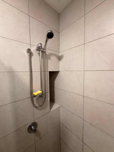 a shower with a shower head in a bathroom at NeoSkyhigh Suites in Batu Kawan