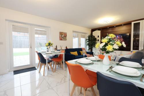 a dining room and living room with a table and chairs at 6 Bedroom Cardiff Stylist Home - 4 Free Private Parking - Ideal for Family & Contractors in Cardiff