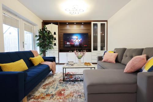 a living room with two blue couches and a tv at 6 Bedroom Cardiff Stylist Home - 4 Free Private Parking - Ideal for Family & Contractors in Cardiff