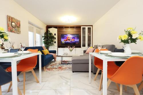 a living room with white tables and orange chairs at 6 Bedroom Cardiff Stylist Home - 4 Free Private Parking - Ideal for Family & Contractors in Cardiff