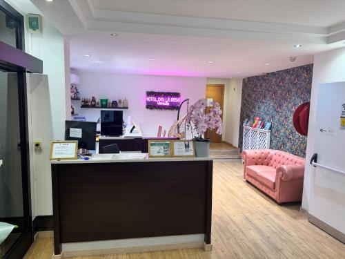 a salon with a pink chair and a counter at Hotel Delle Rose in Mestre