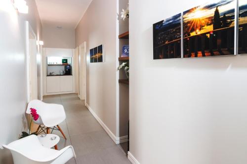 a hallway with two white chairs and a painting on a wall at Prima Luxury Rooms in Split