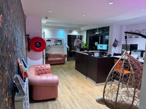 a living room with a pink chair and a desk at Hotel Delle Rose in Mestre