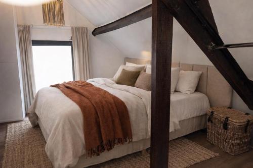 a bedroom with a large bed with white sheets and pillows at De Beijersche Stee , Landhuysje in Stolwijk