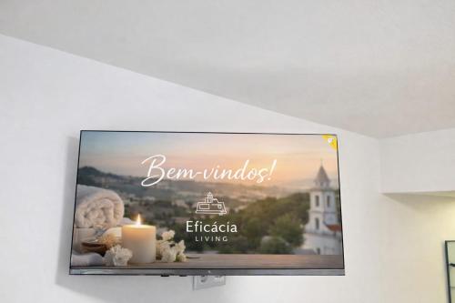 a flat screen tv hanging on a wall with a candle at Spa & Jacuzzi Dupla Privada Escapadinha Romântica Abrantes in Abrantes
