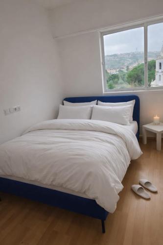a bedroom with a large bed with white sheets and a window at Spa & Jacuzzi Dupla Privada Escapadinha Romântica Abrantes in Abrantes