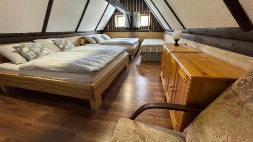a bedroom with two beds and a table and a chair at Chaloupka za mostem Plavy - Jizerské hory in Plavy