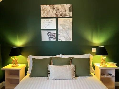 a bedroom with green walls and a bed with pillows at Ye Olde Crown in Edenbridge