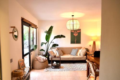 a living room with a couch and a potted plant at Sabinas place in Corralejo