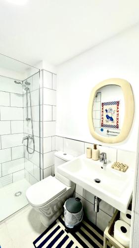 a bathroom with a sink and a toilet and a mirror at Sabinas place in Corralejo