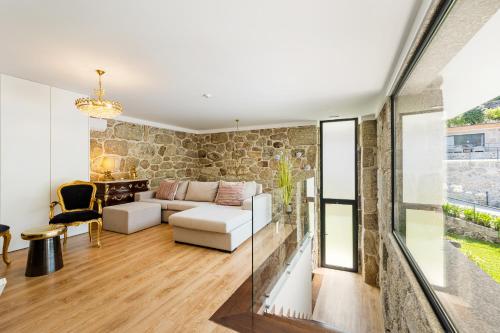 a living room with a stone wall at Vale da Fonte - Charming Houses in Ponte da Barca
