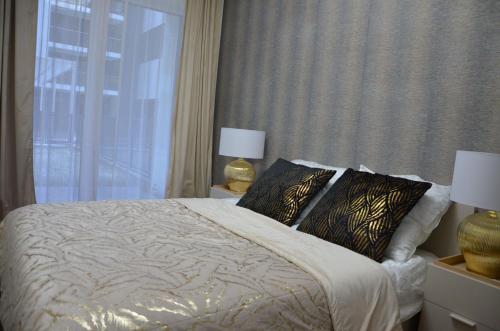 a bedroom with a bed with two pillows and a window at Apartament Eleven Międzyzdroje in Międzyzdroje