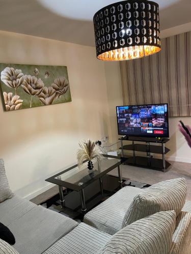 a living room with a couch and a tv at Casa Centro two bedroom apartment in Wolverhampton