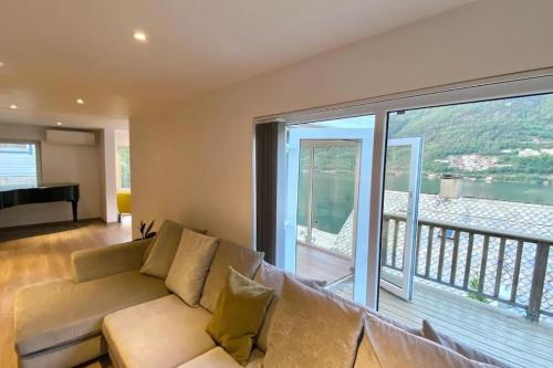 a living room with a couch and a large window at Trolltunga Fjordview House, Odda in Odda