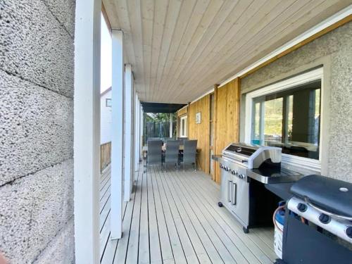 a porch with a stove and a grill on a house at Trolltunga Fjordview House, Odda in Odda
