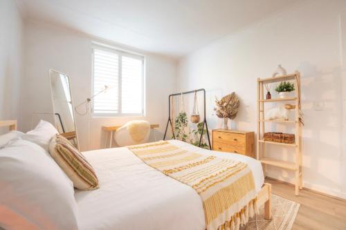 a bedroom with a large white bed and a window at Boho by the Bay in Melbourne
