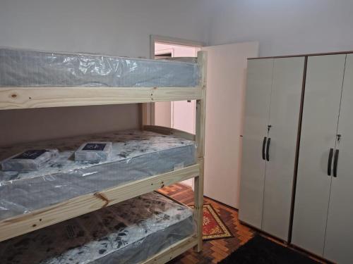 a room with a bunk bed and a closet at Pousada in Porto Alegre