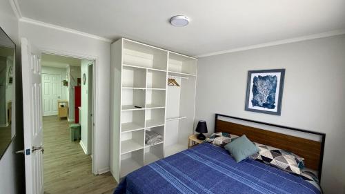a bedroom with a blue bed and white walls at Green House, by Pewma Apart Hotel in Diguillín