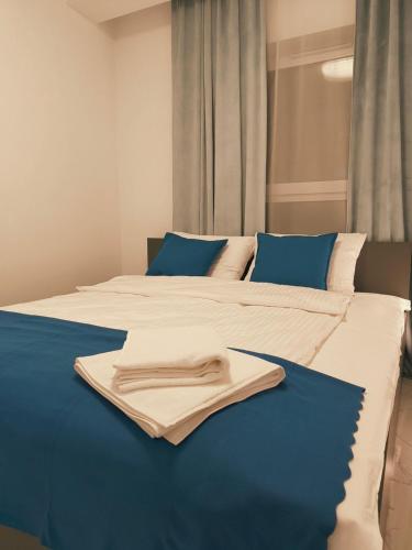 a bed with a towel laying on top of it at Aura Apartamenty 3 in Brzeg