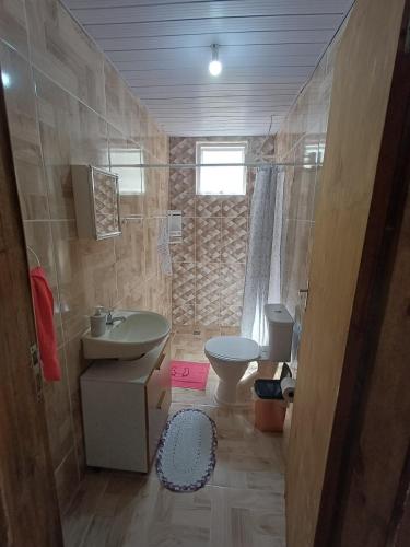 a bathroom with a sink and a toilet at Casa simples a 375 mts da praia in Matinhos