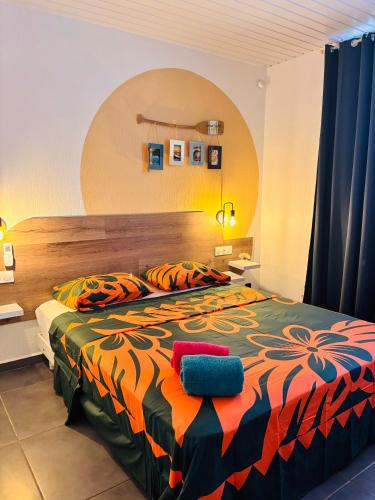 a bedroom with a large bed with a colorful comforter at Airport Pamatai Room in Faaa