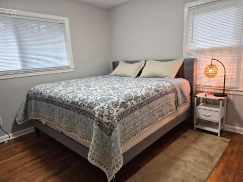 a bedroom with a bed with a blanket and two windows at Villa Nemesio & Linsday 2 in Atlanta