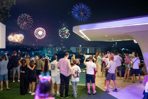 a crowd of people standing around watching fireworks at HOMA Cherngtalay Phuket in Bang Tao Beach