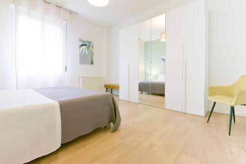 a bedroom with a bed and a chair and a mirror at Ak Holidays Apartment 59 in Bologna