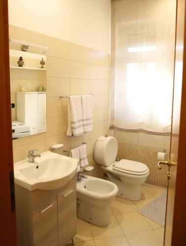a bathroom with a white toilet and a sink at Paradiso dell'Etna in Zafferana Etnea