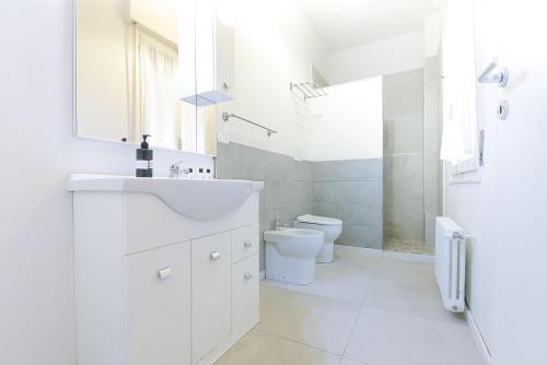 a white bathroom with a sink and a toilet at Ak Holidays Apartment 59 in Bologna