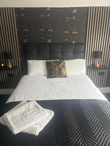 a bedroom with a large bed with a black headboard at Idan House in Llanberis