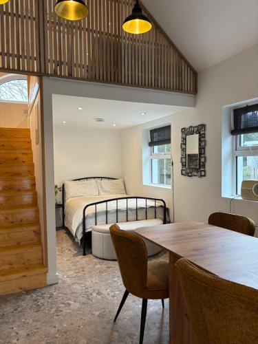 a bedroom with a bed and a table and chairs at Stable Lodge in Killarney
