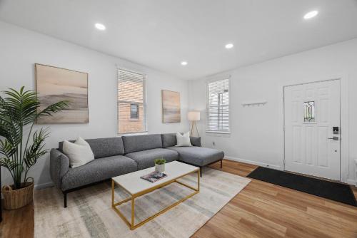 a living room with a couch and a table at Pittsburgh Spacious and Modern Three Bedroom Apartment with Free Parking in Pittsburgh