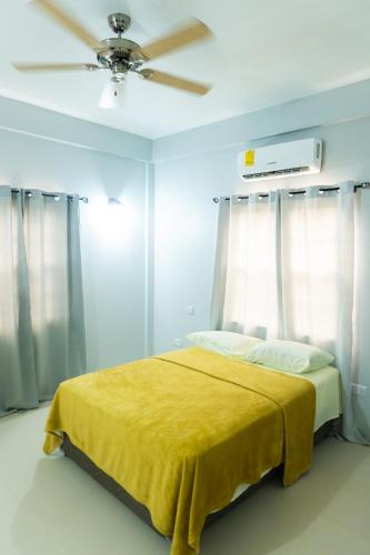 a bedroom with a yellow bed with a ceiling fan at Nook Apartments in Grenville