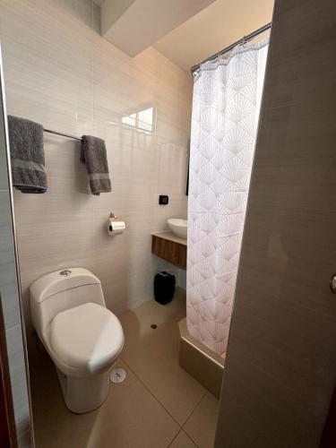 a white bathroom with a toilet and a shower at EL GRAN SEÑORIAL in Jauja