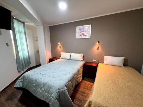 a small bedroom with two beds and a window at EL GRAN SEÑORIAL in Jauja