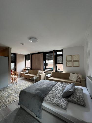 a bedroom with a large bed and a living room at Domblick Apartment in Aachen
