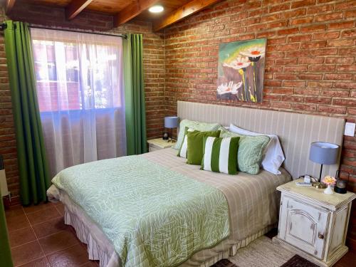 a bedroom with a bed and a brick wall at One Cabañas Vera in Los Antiguos