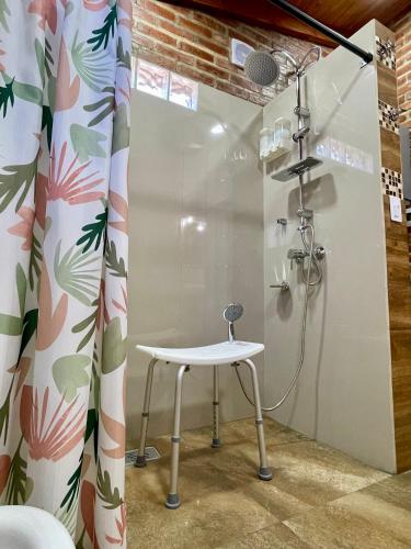 a shower with a stool and a shower curtain at One Cabañas Vera in Los Antiguos