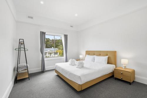 a white bedroom with a bed and a window at Charming Sandy Bay Stay in Sandy Bay