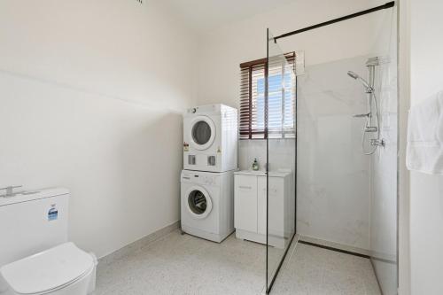 a bathroom with a washing machine and a washer at Charming Sandy Bay Stay in Sandy Bay