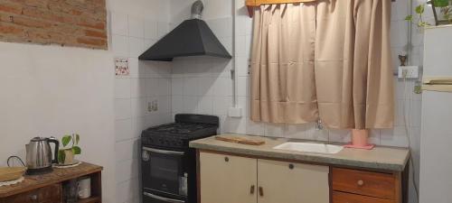 a small kitchen with a stove and a sink at Casa Uchita in La Falda