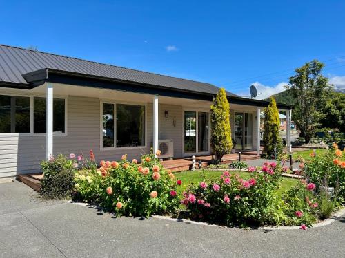 a house with flowers in the front yard at Sunshine cosy retreat in Hanmer Springs