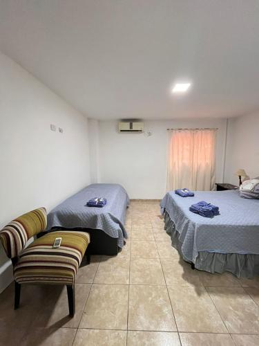 a bedroom with two beds and a couch in it at Edificio LUMARO in San Fernando del Valle de Catamarca