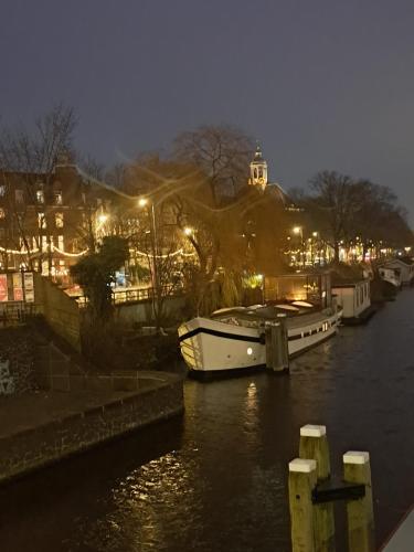 a boat is docked in a river at night at Cornelia Below Deck in Amsterdam