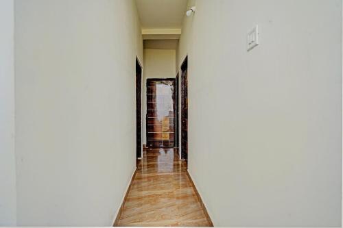a hallway with white walls and wooden floors at Hotel O RJ HOTEL INN in Pānchgaon