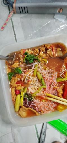 a bowl of food with noodles and chopsticks in it at Love in Ban Khlong Chorakhe
