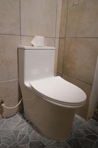 a toilet in a bathroom with a roll of toilet paper on it at Casa Belén in Flores