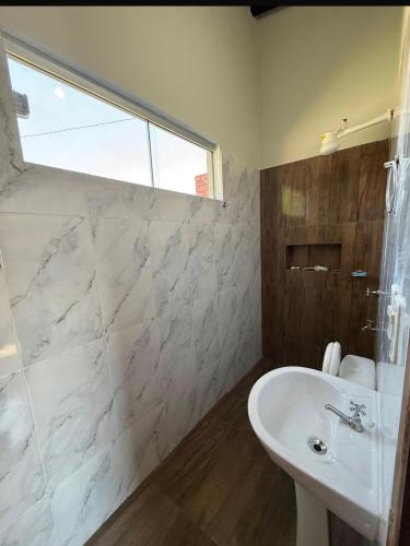 a bathroom with a white sink and a shower at La casita de Ivanna in San Bernardino