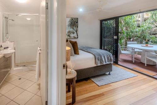 a bedroom with a bed and a bathroom at Shorelines Apartments on Hamilton Island by HIHA in Hamilton Island